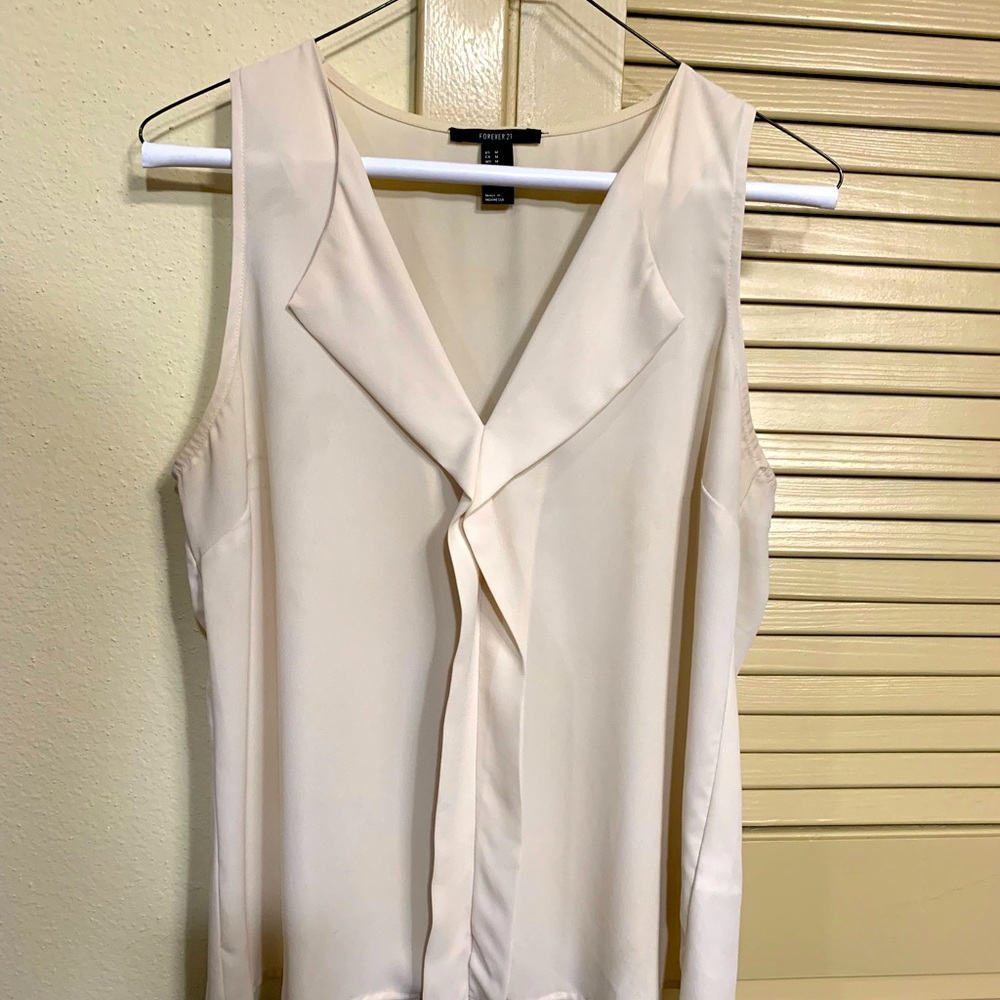 Beige medium size sleeveless blouse.